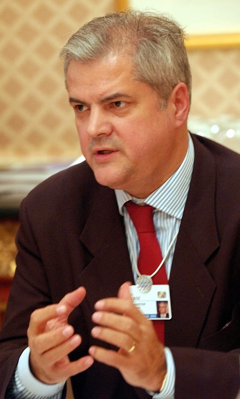 Adrian Năstase îmbrăcat cu un costum negru, purtând o conversație