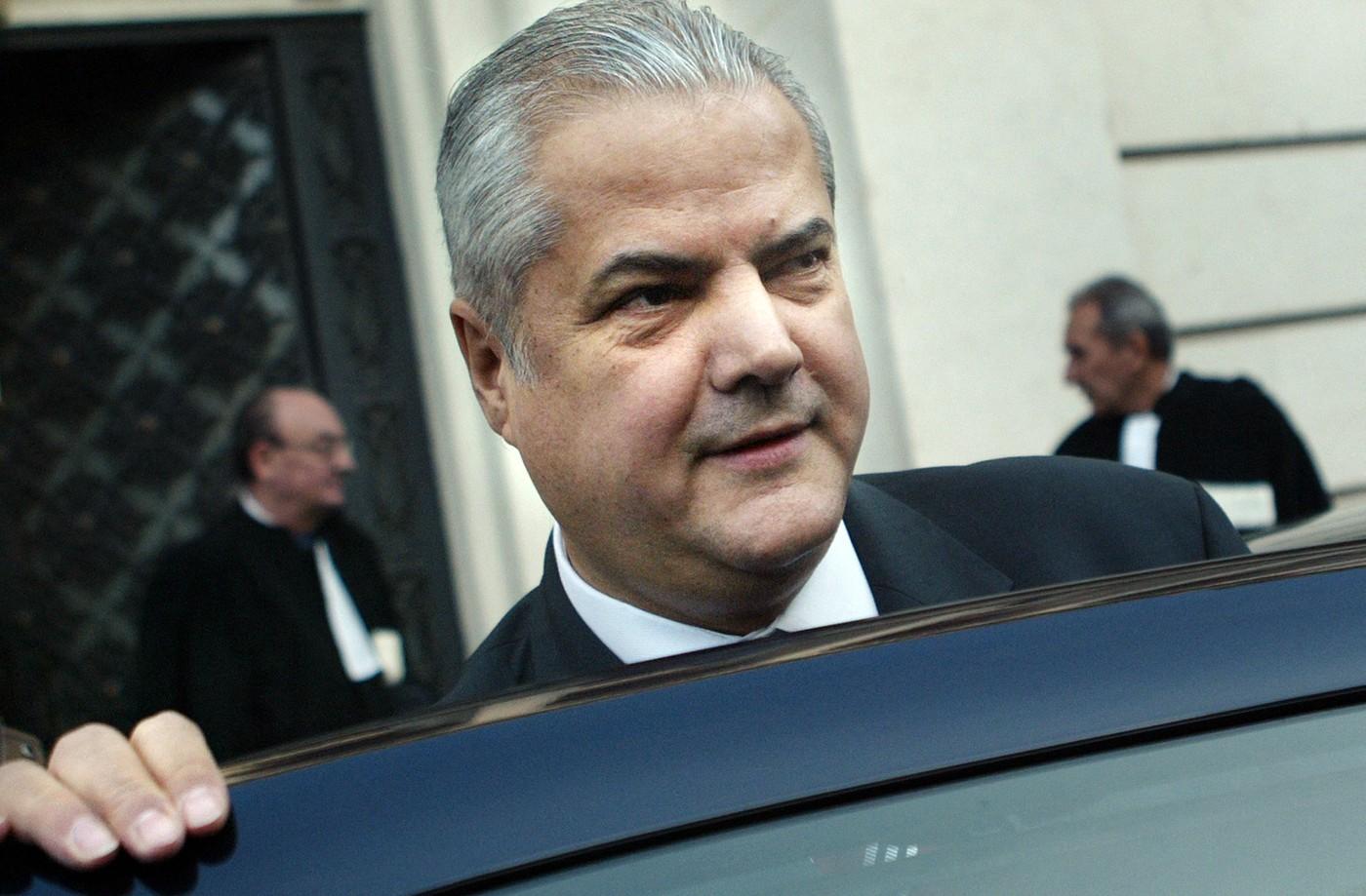 Adrian Năstase îmbrăcat cu un costum negru, coborând dintr-o mașină