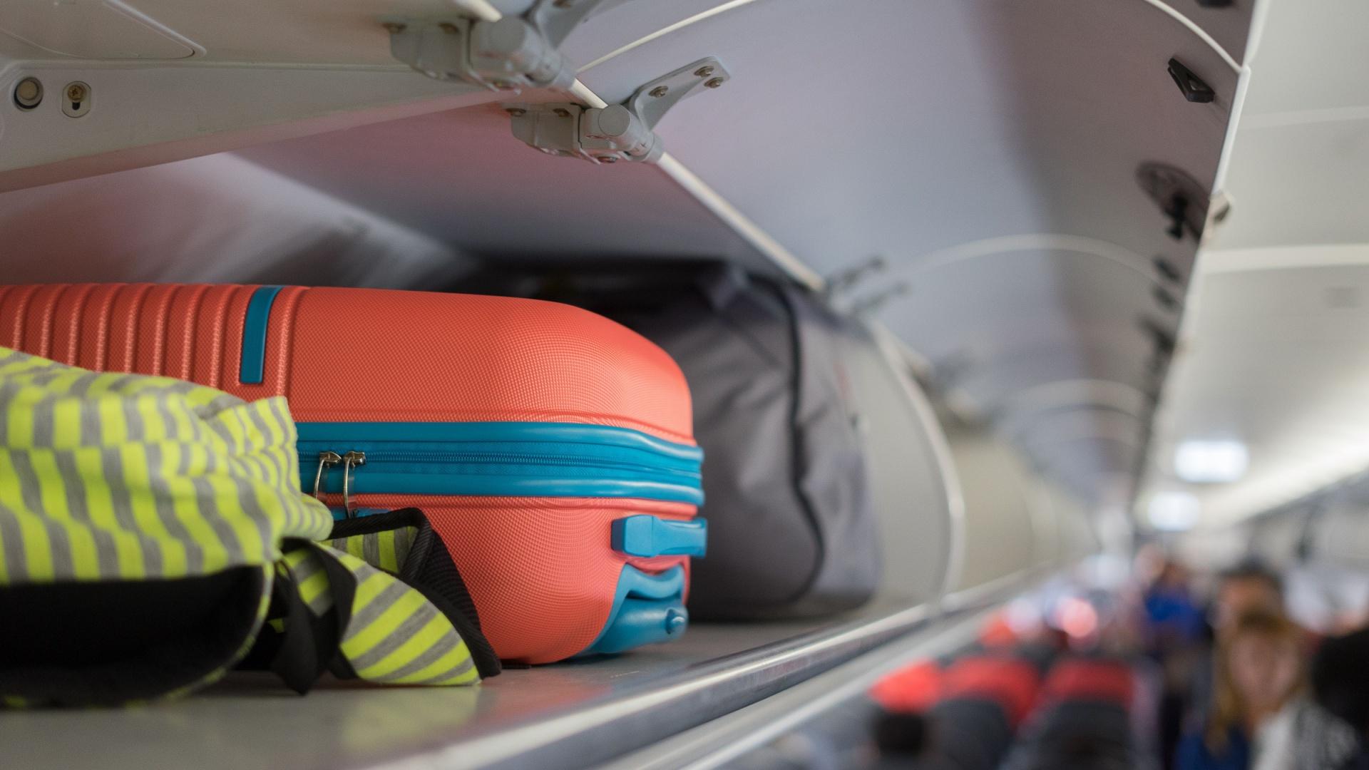 Bagaj de mână pe raftul de sus deasupra capului în avion