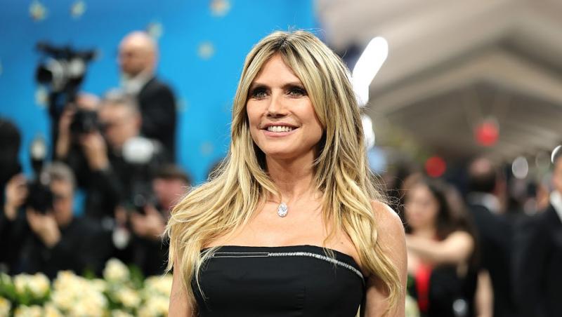 Heidi Klum îmbrăcată într-o rochie neagră mulată, fără mâneci