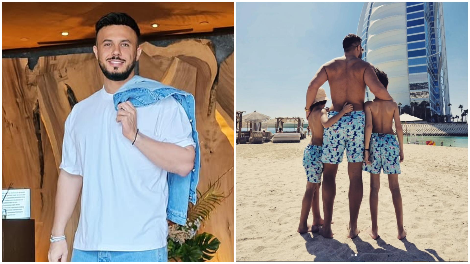 Gabi Bădălău și cei doi băieți ai săi care stau alături de tatăl lor la plajă cu spatele la cameraman