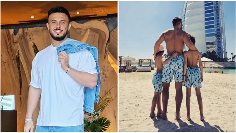 Gabi Bădălău și cei doi băieți ai săi care stau alături de tatăl lor la plajă cu spatele la cameraman