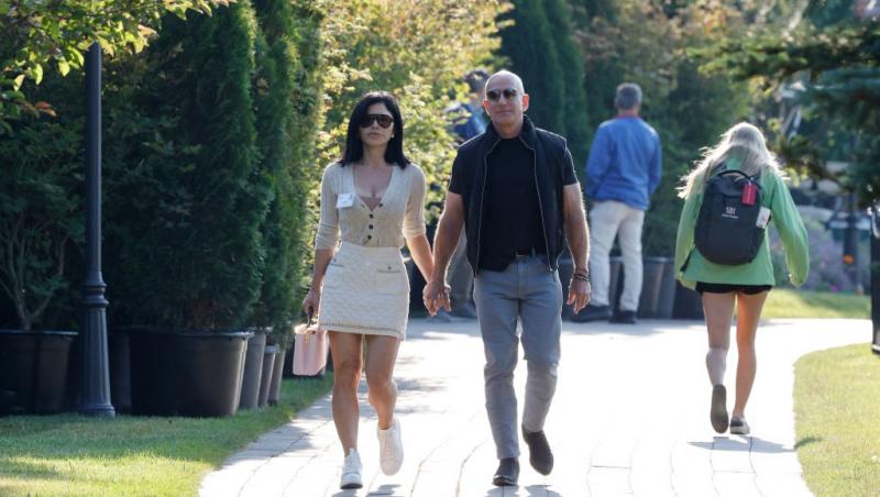 Jeff Bezos ținându-se de mână cu Lauren Sanchez, ambii îmbrăcați casual