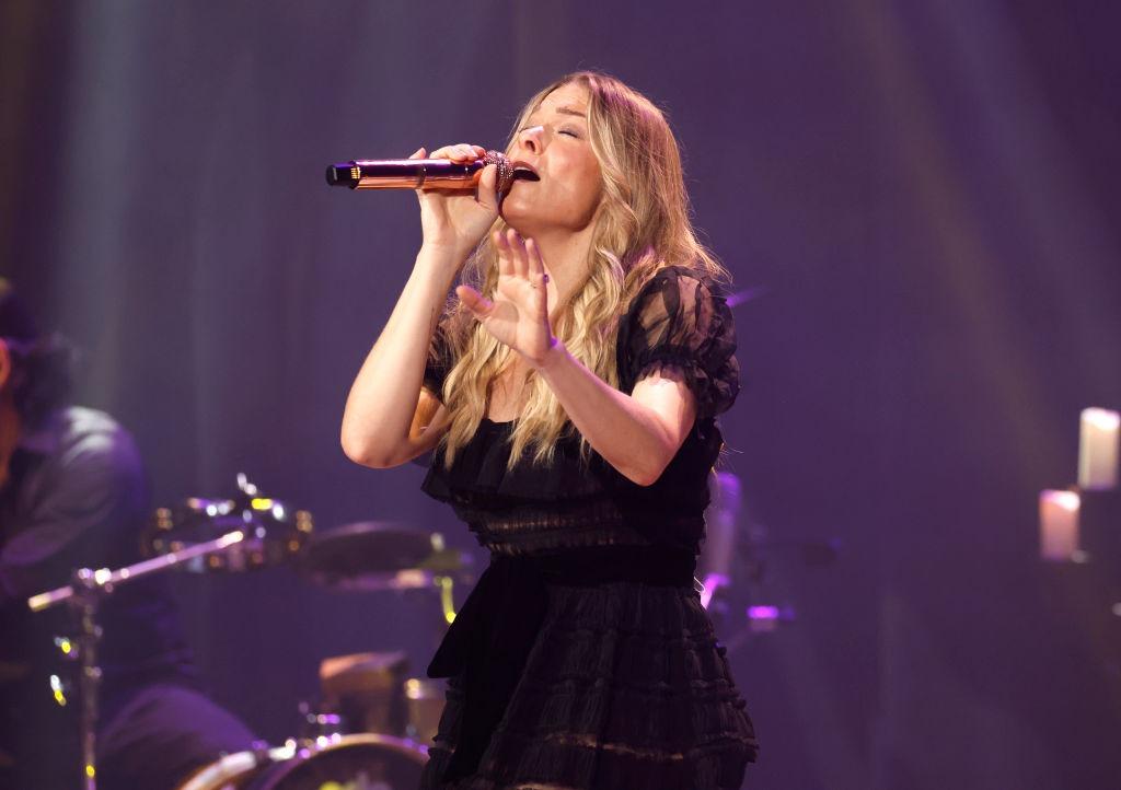 LeAnn Rimes îmbrăcată într-o rochie neagră, cântând pe scenă