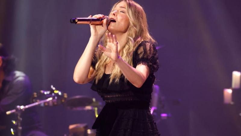 LeAnn Rimes îmbrăcată într-o rochie neagră, cântând pe scenă