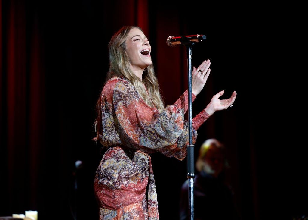 LeAnn Rimes îmbrăcată într-o rochie florală, cântând pe scenă