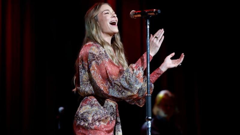 LeAnn Rimes îmbrăcată într-o rochie florală, cântând pe scenă