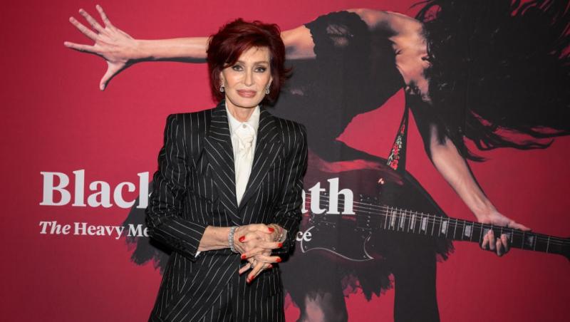 Sharon Osbourne îmbrăcată cu un costum negru cu dungi albe