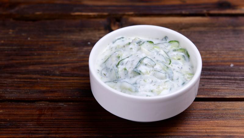 Salată de castraveți cu iaurt și semințe într-un castron alb