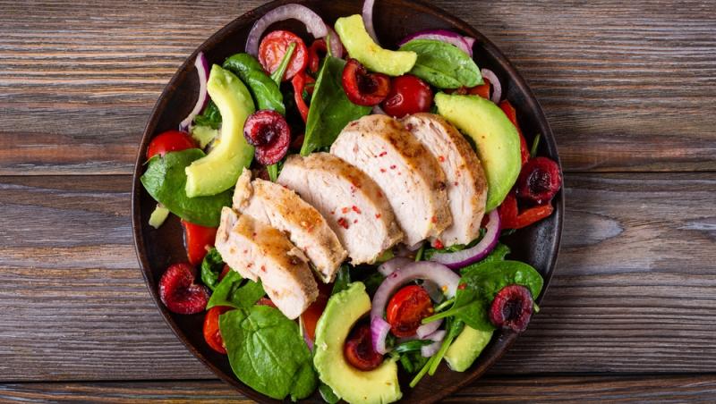 Salată sățioasă cu piept de pui fraged, avocado cremos și frunze proaspete de spanac baby, bogată în proteine și grăsimi sănătoase care susțin energia pe parcursul zilei