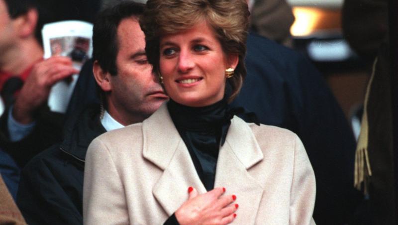 Prințesa Diana îmbrăcată cu un palton bej, accesorizat cu o eșarfă neagră