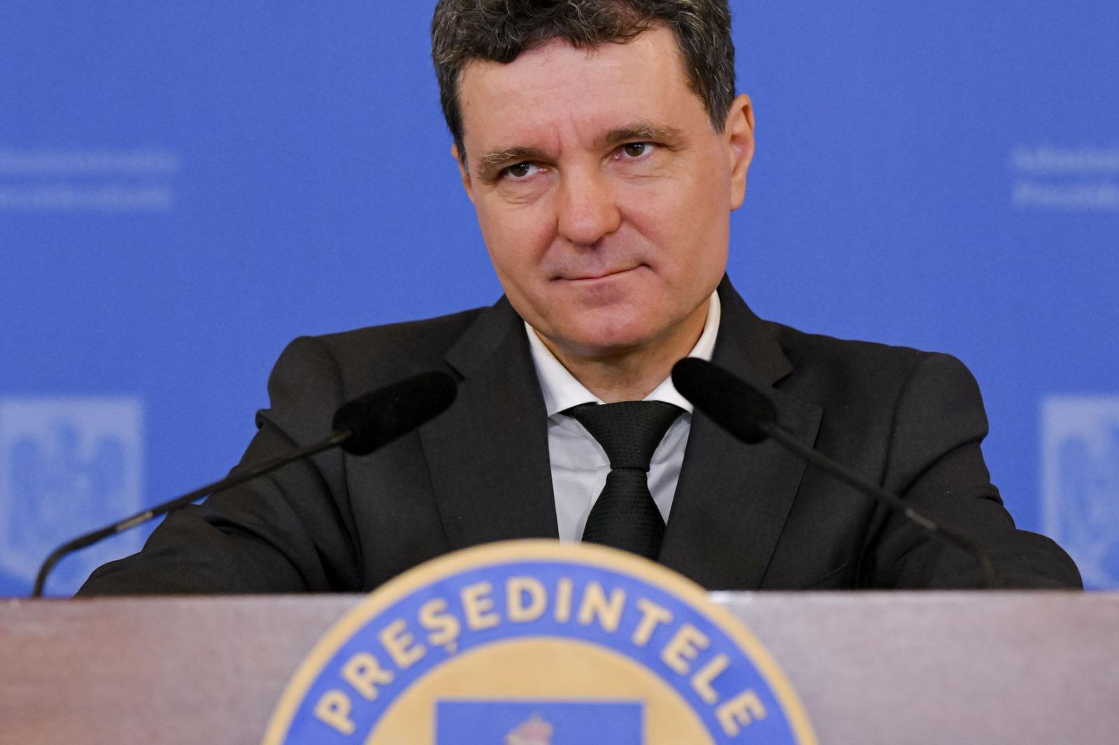 Nicușor Dan îmbrăcat cu un costum negru, vorbind la microfon