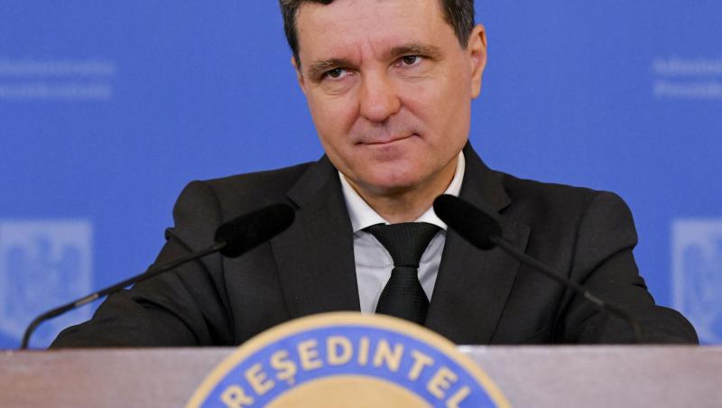 Nicușor Dan îmbrăcat cu un costum negru, vorbind la microfon