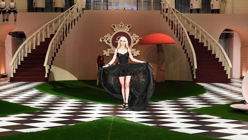 Valeria Lukyanova îmbrăcată într-o rochie neagră cu trenă lungă, defilând la un eveniment