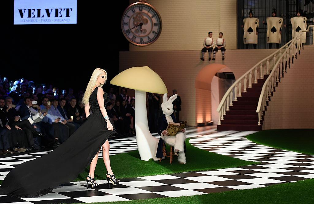 Valeria Lukyanova îmbrăcată într-o rochie neagră cu trenă lungă, defilând la un eveniment