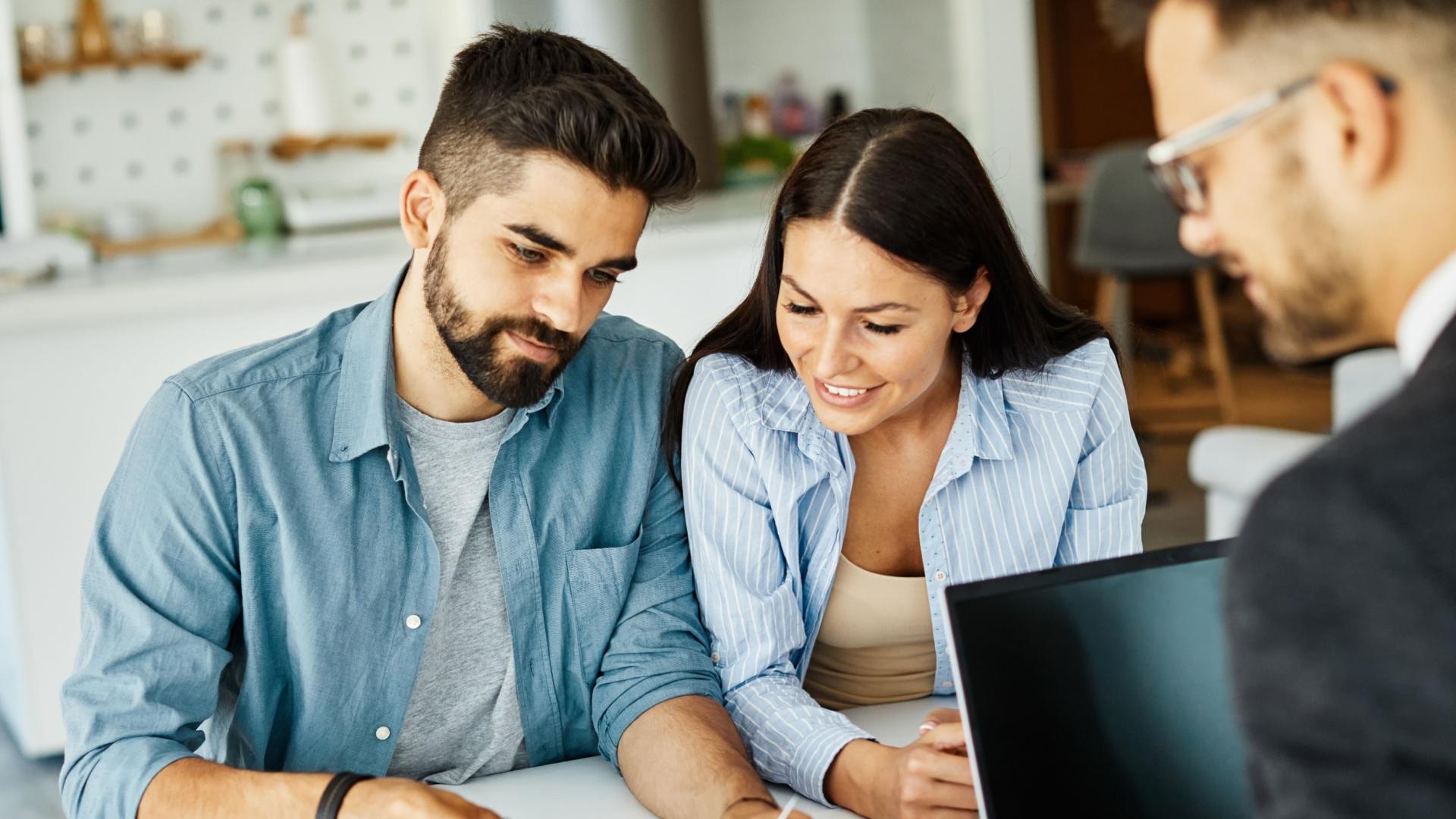 Cuplu tânăr care semnează un credit imobiliar