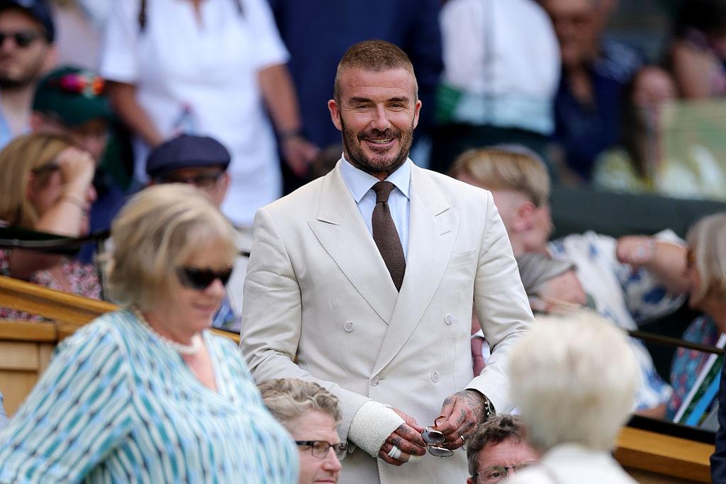 David Beckham alături mama lui, Sandra, la un meci de tenis, ambii îmbrăcați în ținute elegante bej