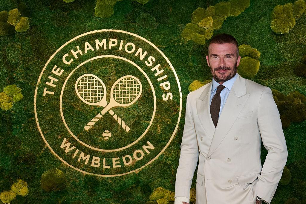 David Beckham la un meci de tenis, îmbrăcat într-un costum bej