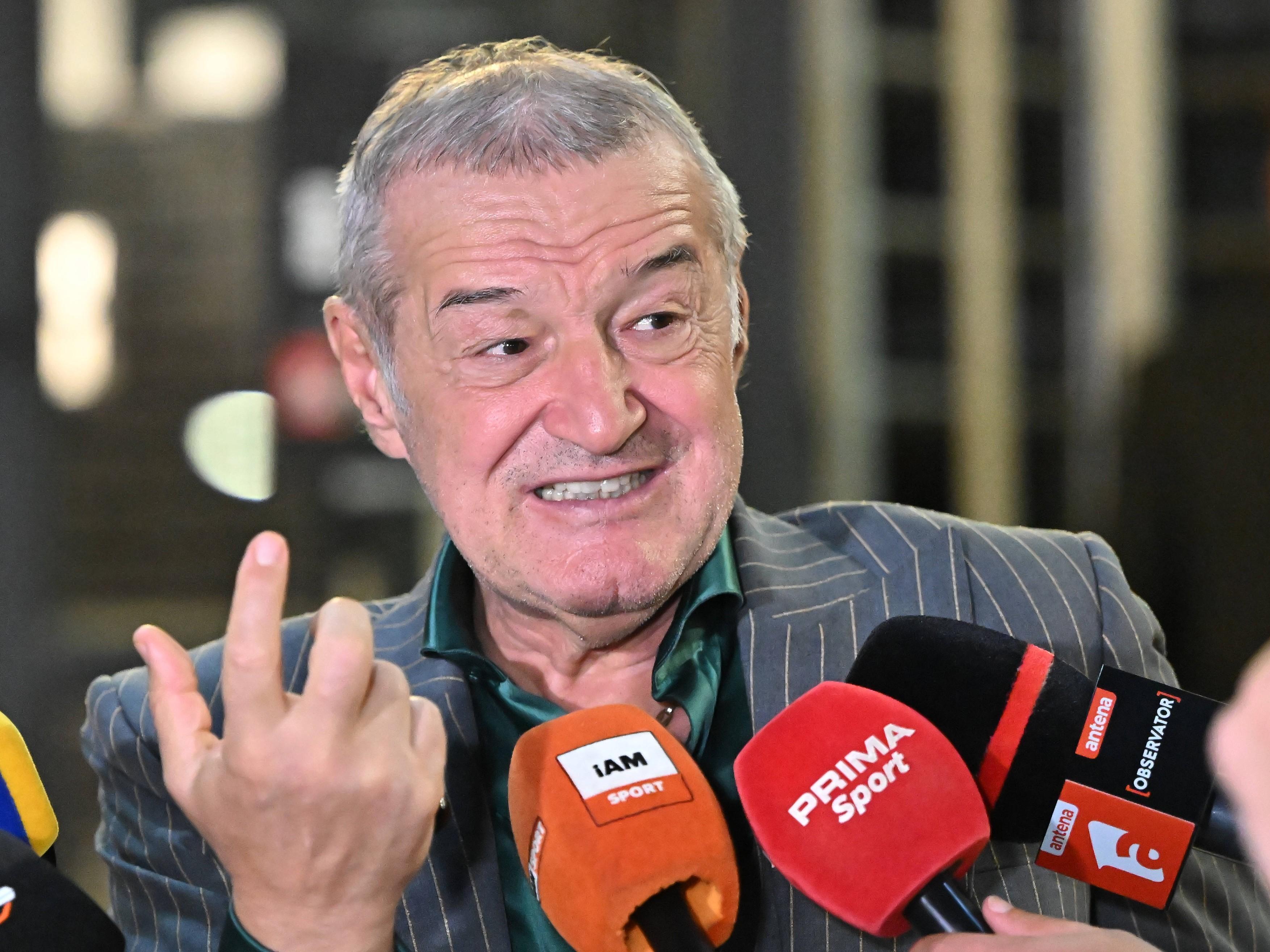 Gigi Becali îmbrăcat într-un costum gri cu dungi și cămașă verde