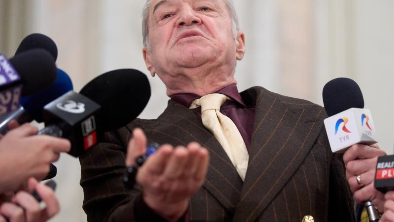 Gigi Becali îmbrăcat într-un costum maro cu dungi, cămașă vișinie și cravată crem