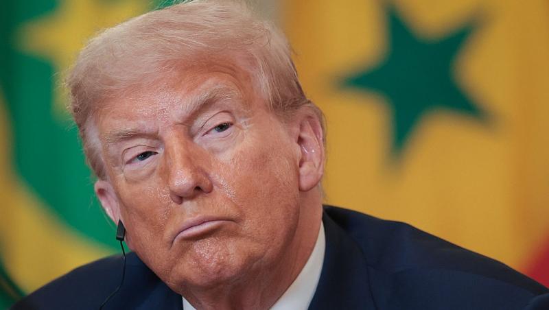 Donald Trump îmbrăcat cu un costum bleumarin și o cravată roșie