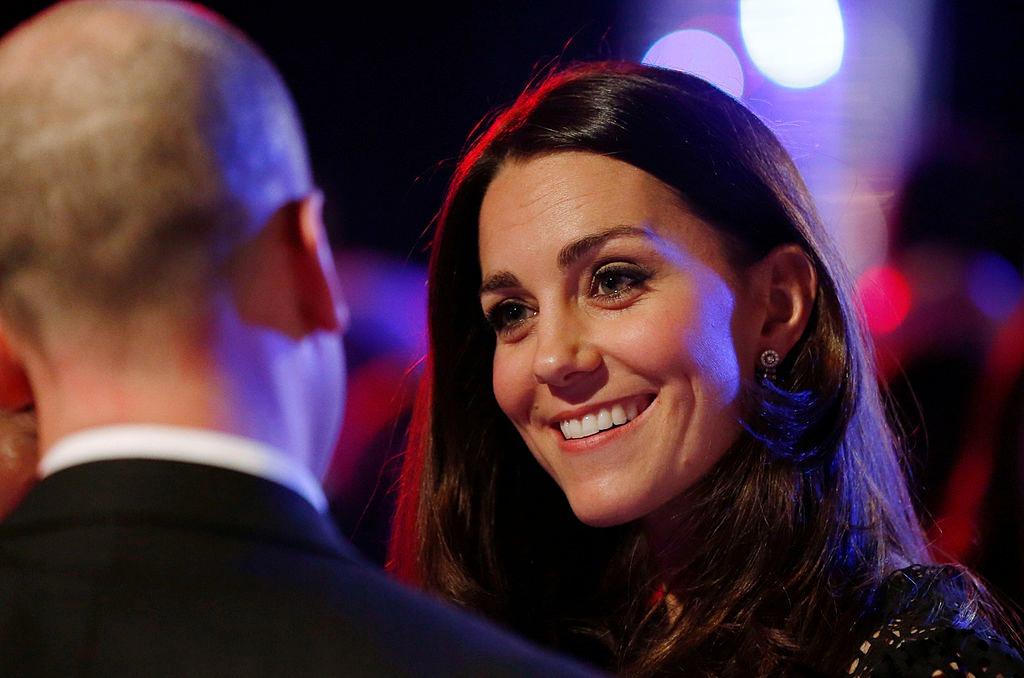 Prințesa Kate îmbrăcată într-o ținută neagră, zâmbind alături de Prințul William