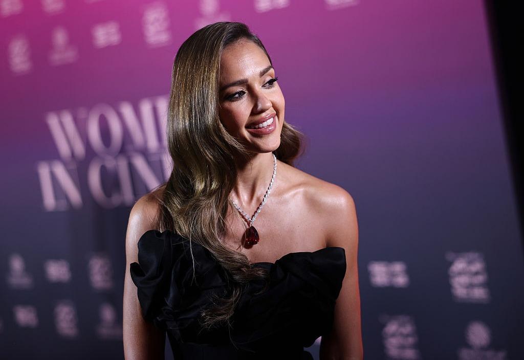 Jessica Alba îmbrăcată într-o rochie neagră, fără mâneci, accesorizată cu un colier strălucitor