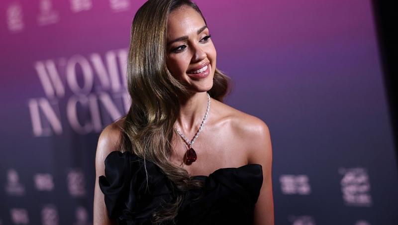 Jessica Alba îmbrăcată într-o rochie neagră, fără mâneci, accesorizată cu un colier strălucitor