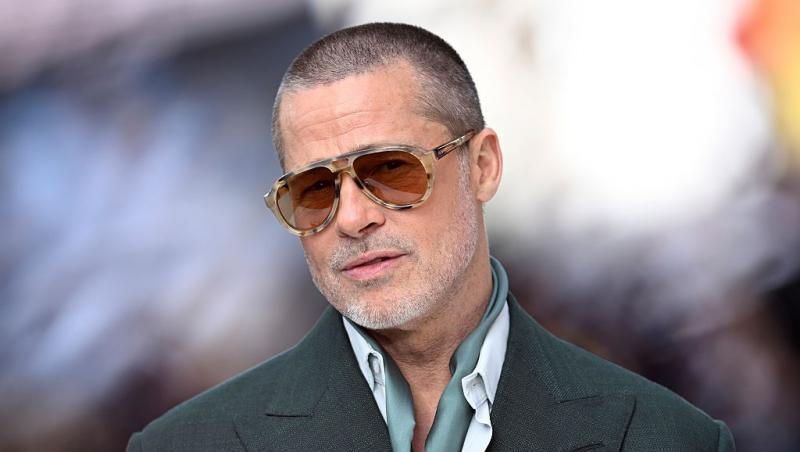 Brad Pitt îmbrăcat cu un sacou gri și ochelari de soare