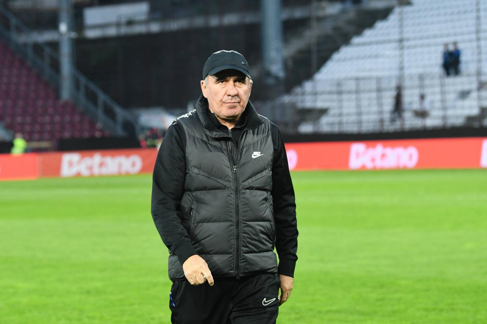 Gheorghe Hagi îmbrăcat în echipament sportiv negru, mergând pe un teren de fotbal
