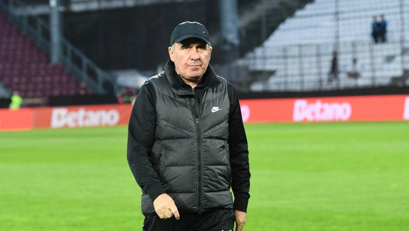 Gheorghe Hagi îmbrăcat în echipament sportiv negru, mergând pe un teren de fotbal