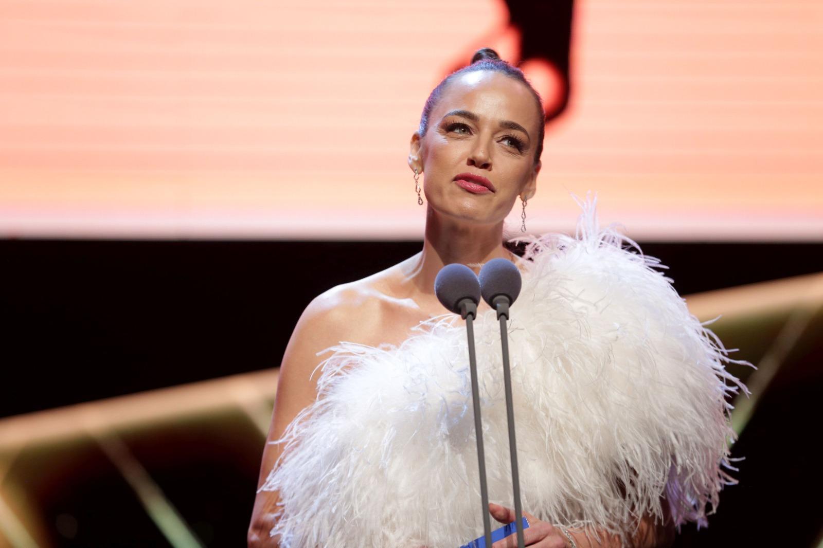 Andreea Raicu îmbrăcată cu o ținută albă, pufoasă