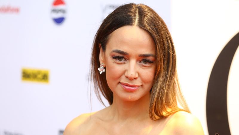 Andreea Raicu îmbrăcată cu o rochie elegantă, fără mâneci