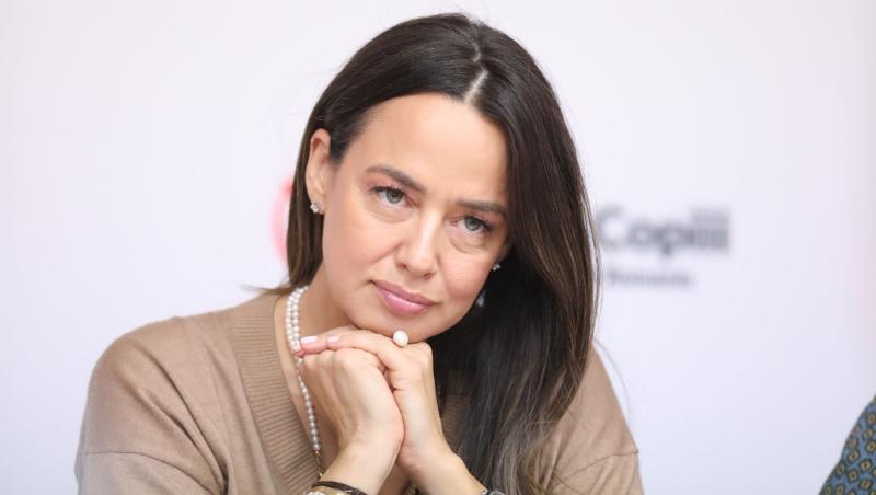 Andreea Raicu îmbrăcată cu o bluză bej