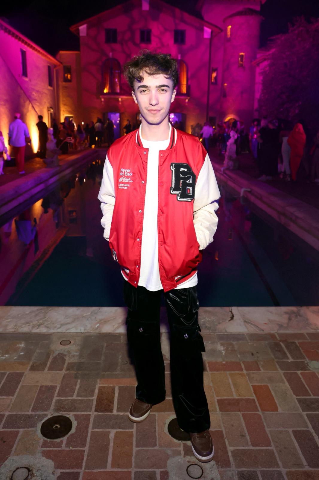 Răzvan Gogan îmbrăcat cu pantaloni negri și o jachetă roșie cu mâneci albe