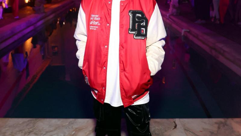 Răzvan Gogan îmbrăcat cu pantaloni negri și o jachetă roșie cu mâneci albe