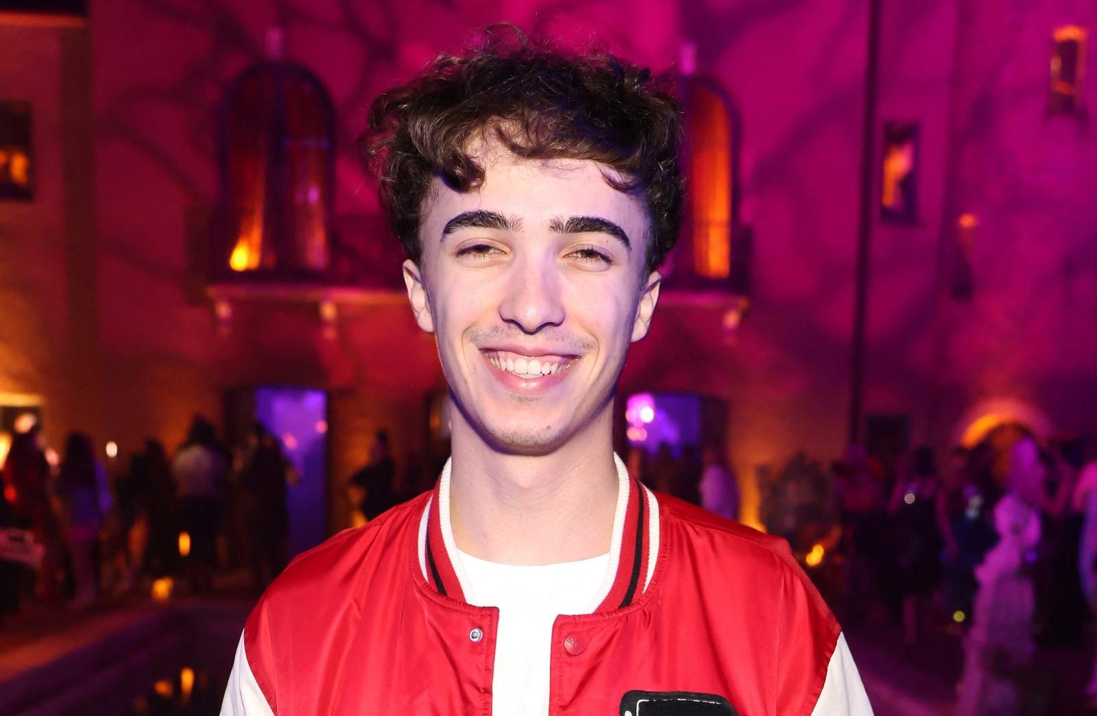 Răzvan Gogan îmbrăcat cu pantaloni negri și o jachetă roșie cu mâneci albe