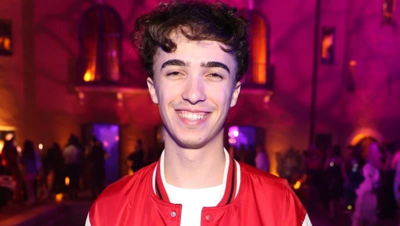 Răzvan Gogan îmbrăcat cu pantaloni negri și o jachetă roșie cu mâneci albe