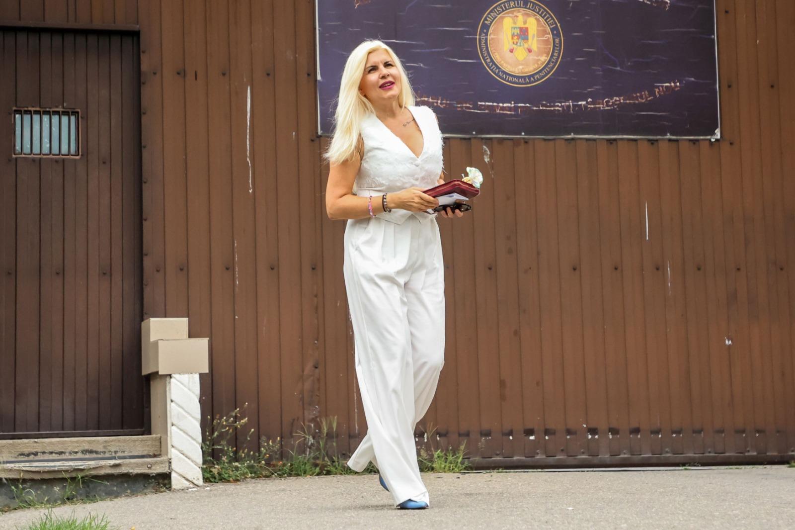 Elena Udrea îmbrăcată într-o ținută complet albă, mergând