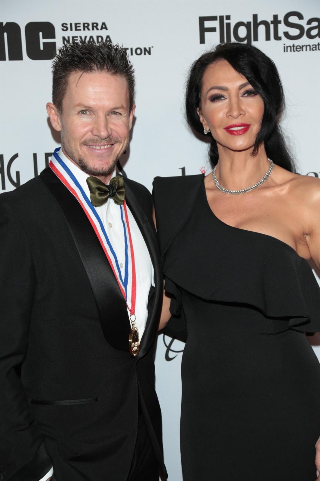 Felix Baumgartner îmbrăcat într-un costum negru, alături de Mihaela Rădulescu, îmbrăcată într-o rochie neagră