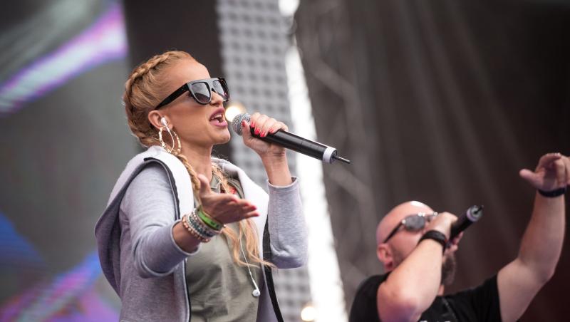 Anda Adam îmbrăcată casual, cântând pe scenă