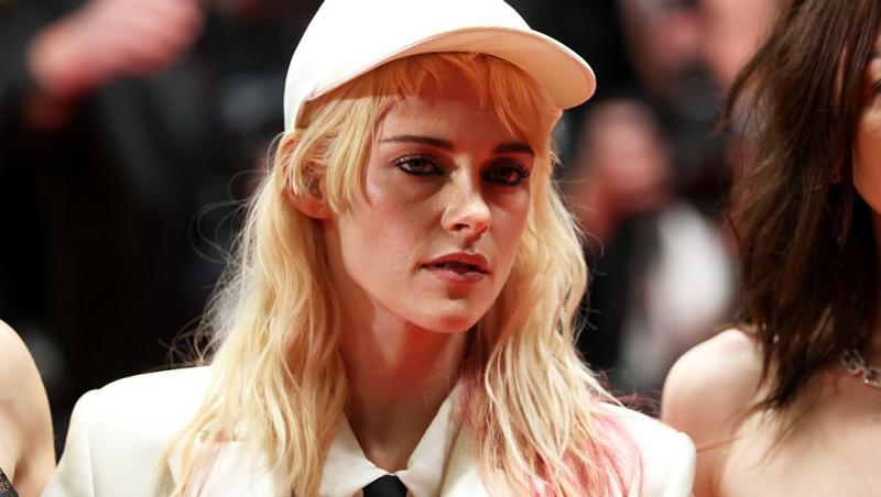 Kristen Stewart îmbrăcată cu un sacou alb și o șapcă asortată