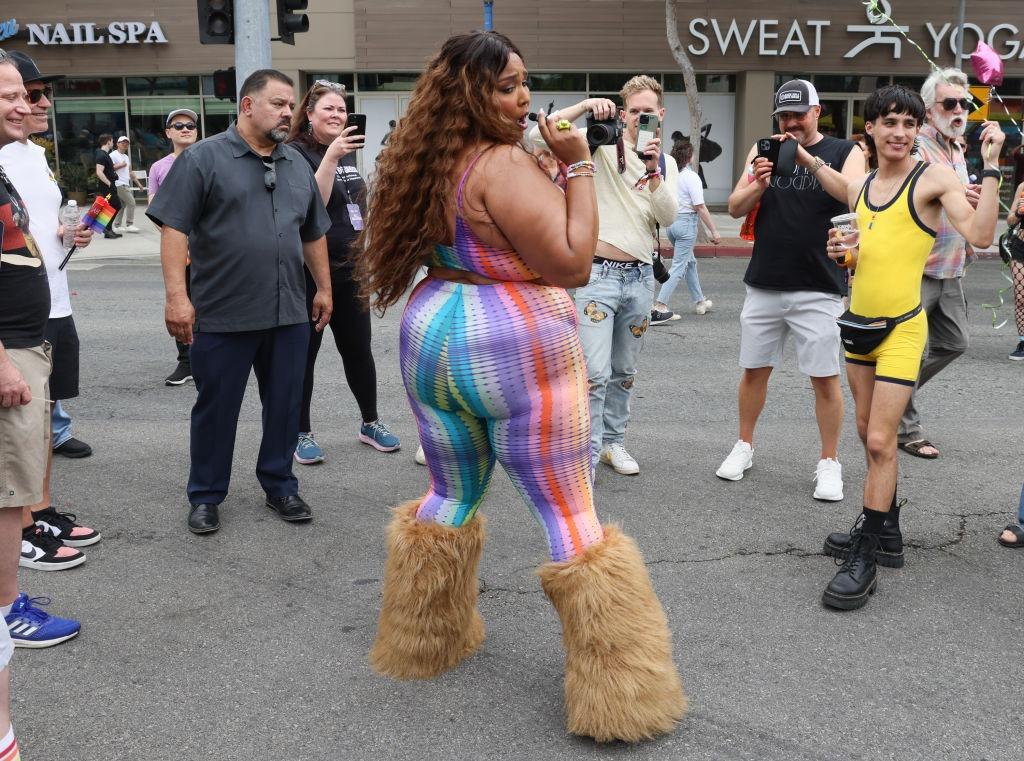 Lizzo îmbrăcată într-o ținută colorată, dansând în stradă