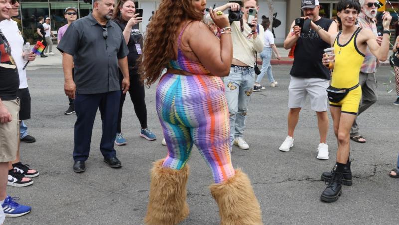 Lizzo îmbrăcată într-o ținută colorată, dansând în stradă