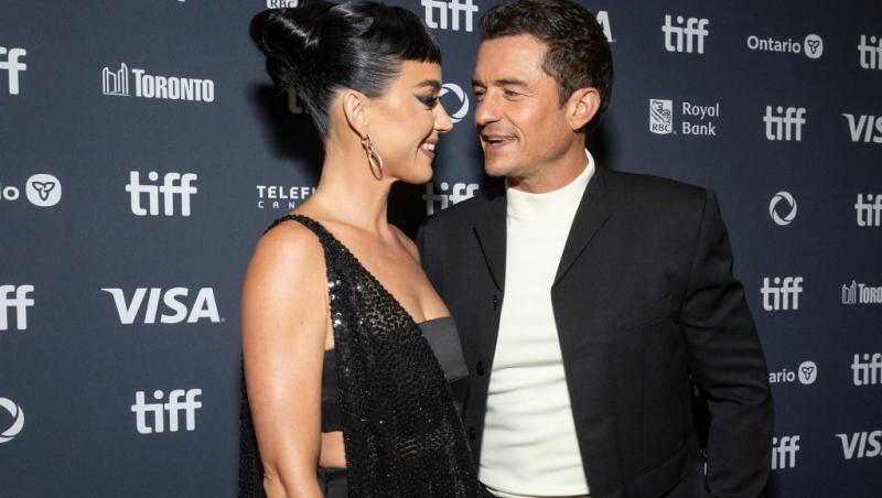Katy Perry și Orlando Bloom îmbrăcați elegant, ținându-se de mână și zâmbind