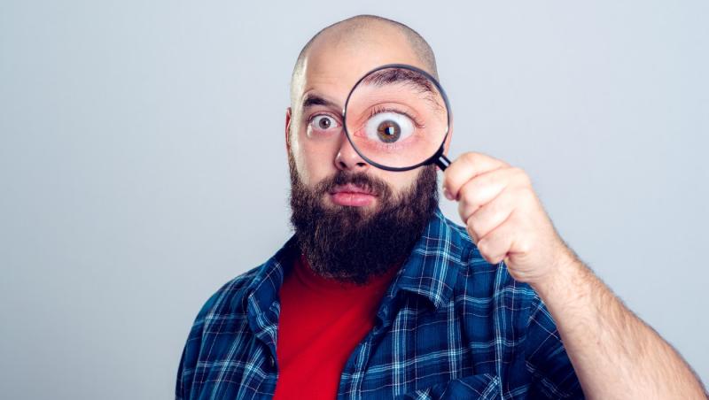 barbat care priveste prin lupa