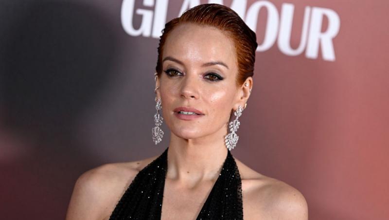 Lily Allen îmbrăcată într-o rochie neagră, decoltată, fără mâneci