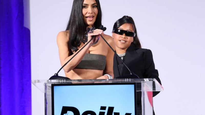 Kim Kardashian alături de fiica ei, North West, vorbind la microfon