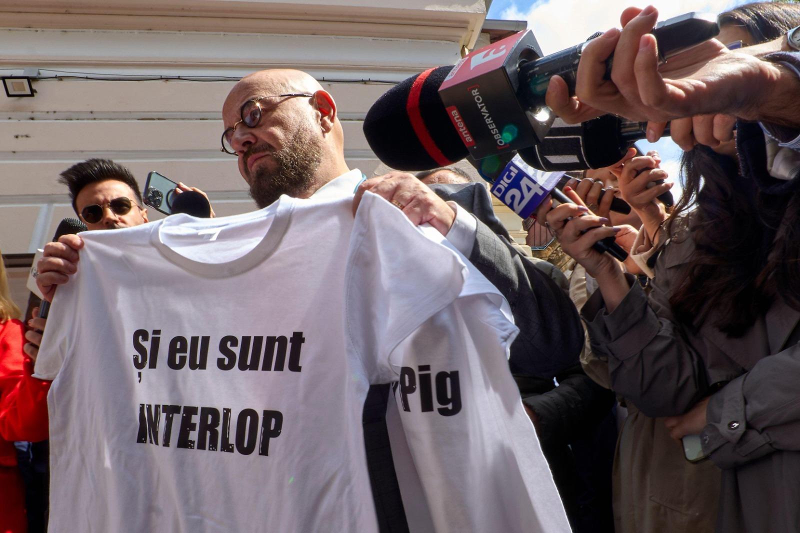 Piedone îmbrăcat cu un costum negru, la o conferință de presă