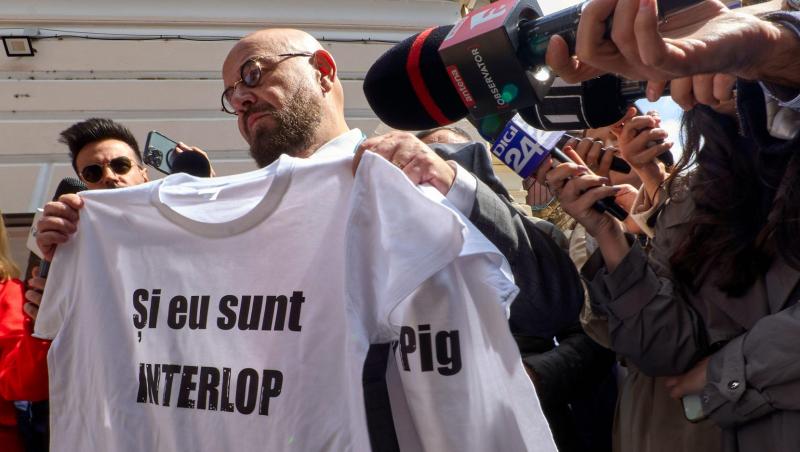 Piedone îmbrăcat cu un costum negru, la o conferință de presă
